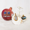 Talismans in gold displayed on fruit and shell. Made by Jesse Ball at Jupiter's Grace