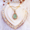 9ct gold pendant talisman with emerald. Displayed on a vintage jewellery box