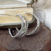 Silver hoop earrings organic shape with bobbles, displayed on a jewellery box