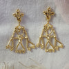 Gold Tribus earrings displayed on calico