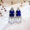 silver earrings with lapis lazuli and pearls displayed on white painted pottery. Made by Jesse Ball at Jupiter's Grace